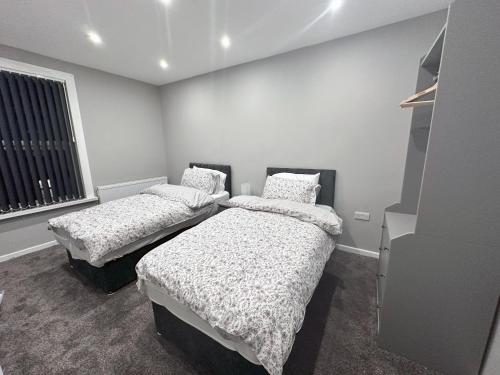 a bedroom with two beds and a window at Modernised 4 Bedroom House close to city Centre, Kep Stays in Leeds