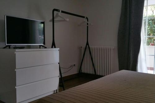 a bedroom with a dresser with a television on top of it at Cristina’s flat Riccione in Riccione
