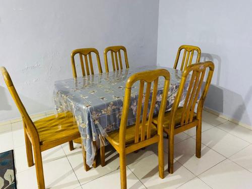 a dining room table with four chairs and a blue table cloth at ZR Homestay Kemaman with 3 Bedroom 2 Bathroom - 2 Room AC 1 Room Fan - Not Sharing House in Cukai
