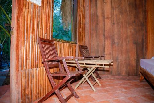 two chairs and a wooden table on a patio at HƯNG THÀNH HOME in Ben Tre