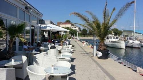 a row of tables and chairs next to a marina at Neversea Black Sea in Constanţa