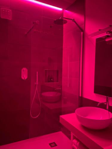 a pink bathroom with a sink and a shower at Villa Carlotta in Salionze