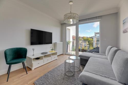 - un salon avec un canapé et une télévision dans l'établissement Comfort Apartments Kopernika, à Gdynia
