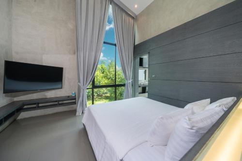 a bedroom with a large bed and a large window at Villa Lami - Tropical Modern Loft Phuket with 3BD, private pool, Gym and Sauna in Phuket Town