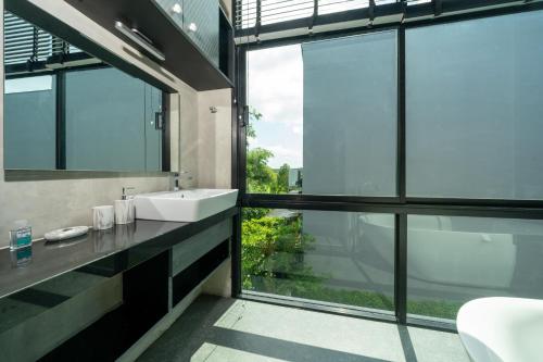 a bathroom with a sink and a large window at Villa Lami - Tropical Modern Loft Phuket with 3BD, private pool, Gym and Sauna in Phuket Town