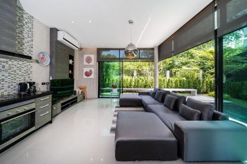 a living room with a large couch and a tv at Villa Lami - Luxury 3-Bedroom Modern Villa in Phuket with Private Pool, Gym & Sauna in Phuket