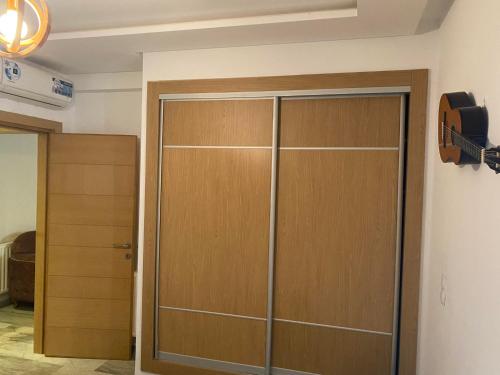 einen Schrank mit einer Holztür in einem Zimmer in der Unterkunft luxe et confort appartement Sahloul 4 in Sousse
