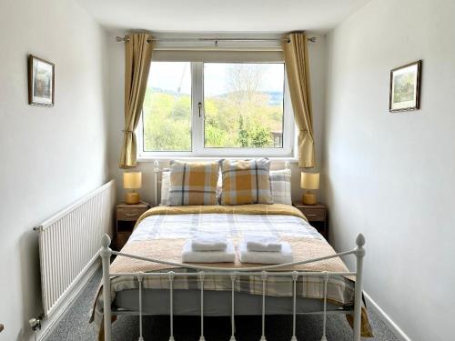 a bed in a room with a window at Miners cottage(1840)Nr. Brecon,Tower Zip & Bike Pk in Aberdare