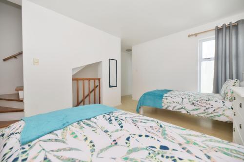 a bedroom with two beds and a window at 25 The Tides in Struisbaai