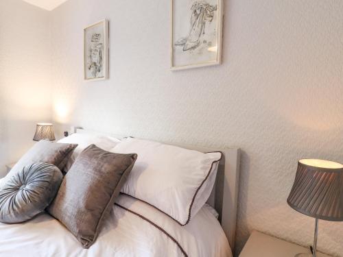 a bedroom with a bed with white sheets and pillows at George's Place in Froghall