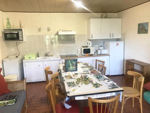 uma cozinha com uma mesa e uma cozinha com armários brancos em Chalet du Renard em Aillon-le-Jeune