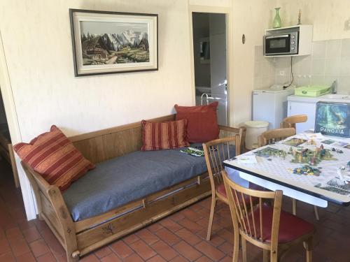 um sofá num quarto com uma mesa e uma cozinha em Chalet du Renard em Aillon-le-Jeune