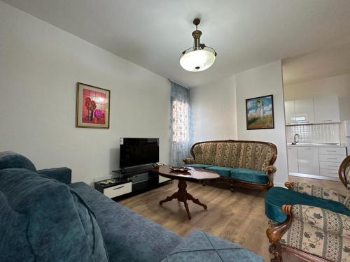 un soggiorno con divano e tavolo di Four Seasons Apartment a Durrës