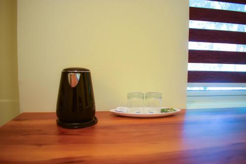 a vase sitting on a wooden table with two glasses at A S Manzil Lounge in Trivandrum