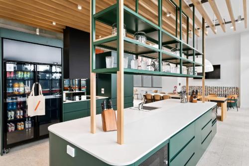 a kitchen with green cabinets and a counter top at Switch Living in the Centre of Adelaide in Adelaide