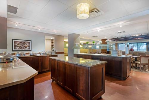 a large kitchen with wooden cabinets and a dining area at Best Western PLUS Port O'Call Hotel in Calgary
