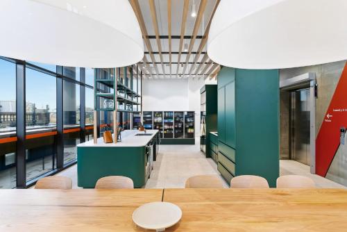 a dining room with a table and chairs and windows at Switch Living in the Centre of Adelaide in Adelaide