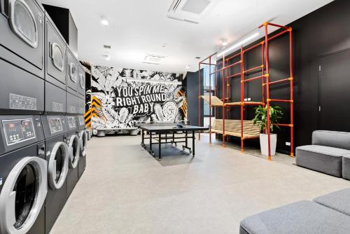 a laundry room with a table and washing machines at Switch Living in the Centre of Adelaide in Adelaide