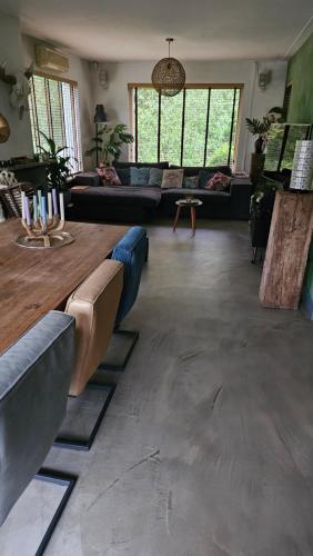 uma grande sala de estar com sofás e uma mesa em Villa in the forrest of Amsterdam with Pool em Velsen-Zuid