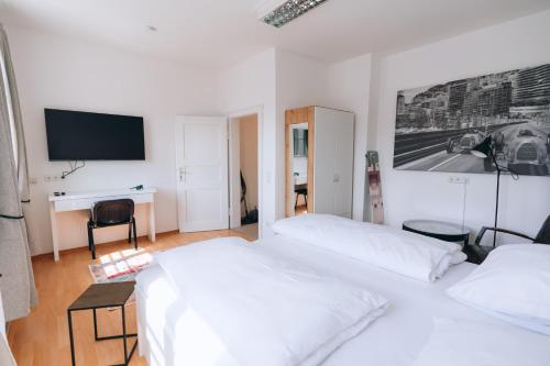 een slaapkamer met 2 bedden en een bureau met een televisie bij Apartment mit großer Küche in der Ingolstädter City in Ingolstadt