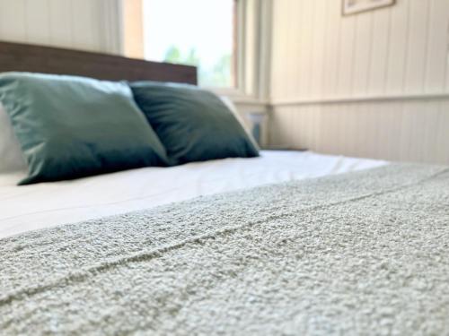 a bed with a green pillow on top of it at Gloucester Serviced Apartments in Gloucester