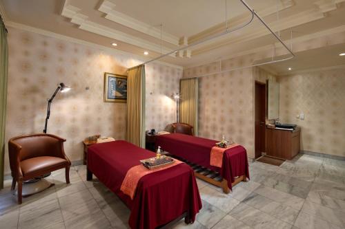 a hospital room with two beds and two chairs at Grand Istana Rama Hotel in Kuta