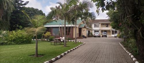 a house with a palm tree next to a driveway at Karibu Heritage House in Arusha