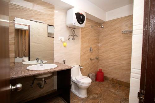 y baño con aseo, lavabo y ducha. en Tiara Regency Gangtok en Gangtok