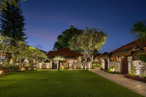 a house with a green lawn in front of it at Grand Istana Rama Hotel in Kuta