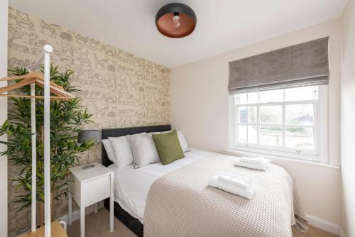 um pequeno quarto com uma cama e uma janela em 1 Victoria Place em Bath