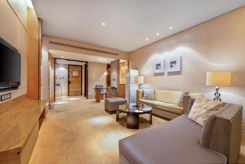 a living room with a couch and a television at Sheraton Zhongshan Hotel in Zhongshan