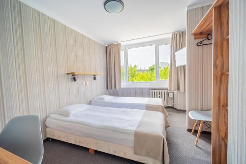 a hotel room with a bed and a window at Hotel Mazowiecki Łódź in Łódź
