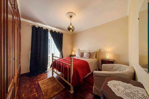 1 dormitorio con 1 cama con manta roja en Casa do Tornadouro, en Ponta do Sol