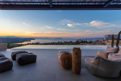 a patio with chairs and a view of a pool at Villa Alchaca - New Magnificent Villa with Infinity Pool & Tennis in Kilada