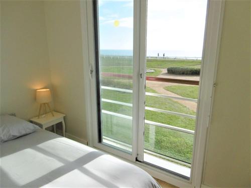 a bedroom with a large window with a view of the beach at Appartement 4 pièces 6 personnes Vue imprenable sur l'océan - STERENN in Sarzeau