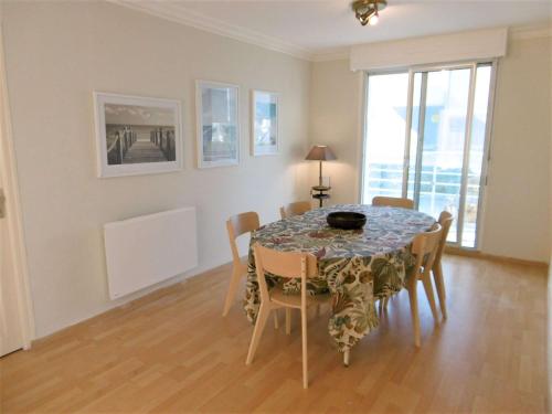 une salle à manger avec une table, des chaises et des fenêtres dans l'établissement Appartement 4 pièces 6 personnes Vue imprenable sur l'océan - STERENN, à Sarzeau