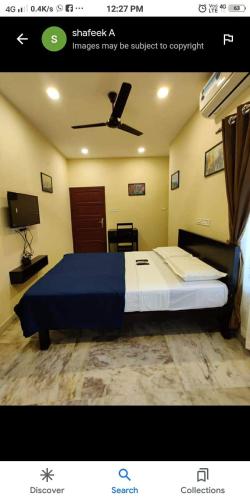 a bedroom with a large bed with a ceiling fan at A S Manzil Lounge in Trivandrum