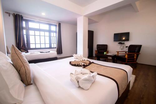 a hotel room with a large bed with towels on it at Tiara Regency Gangtok in Gangtok