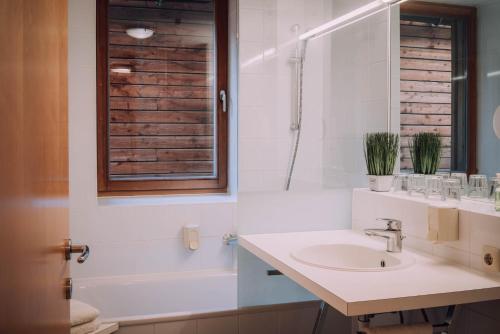 a white bathroom with a sink and a shower at Apartment Auenfeld in Schröcken