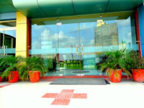 a lobby with potted plants in front of a building at Hotel Gangotri Haridwar in Haridwār