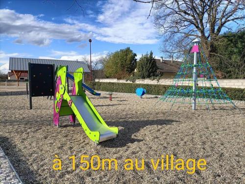 a playground with a slide and a play structure at La Villa aux Bananiers 