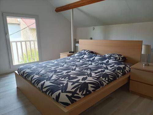 a bedroom with a bed with a blue and white comforter at La Villa aux Bananiers 