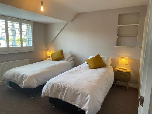 2 Betten in einem kleinen Zimmer mit 2 Lampen in der Unterkunft Sunny Days: Beautiful Spacious 4 bed house in Torquay