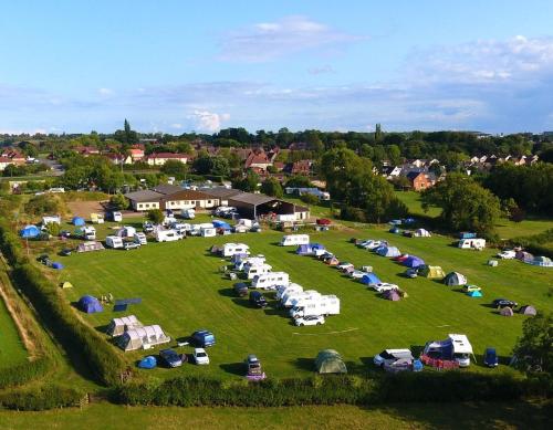 una vista aérea de un gran campo con muchas tiendas de campaña en Silverstone Farm Campsite en Silverstone