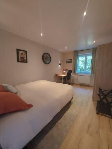 a bedroom with a large white bed and a desk at Logement à 6 minutes du parc des expositions. in Chavagne