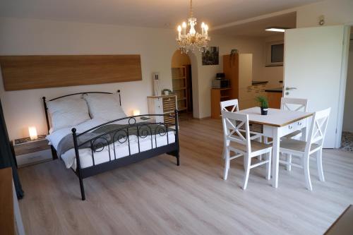 a bedroom with a bed and a table and a dining room at Gemütliches Apartment im Wald - Netflix & Prime in Marktleugast