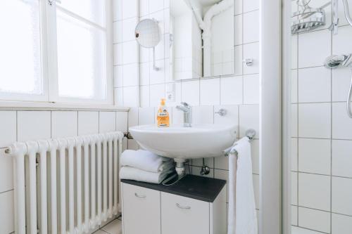 een witte badkamer met een wastafel en een spiegel bij Apartment mit großer Küche in der Ingolstädter City in Ingolstadt