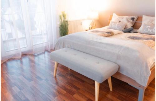 a bedroom with a large bed with a bench on it at Ferienwohnung Prestige 1 in Friedrichshafen