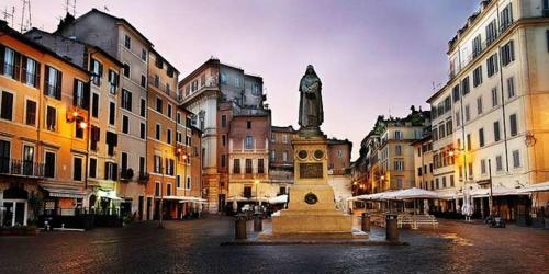 una estatua en medio de una ciudad con edificios en Hybris Campo De' Fiori, en Roma