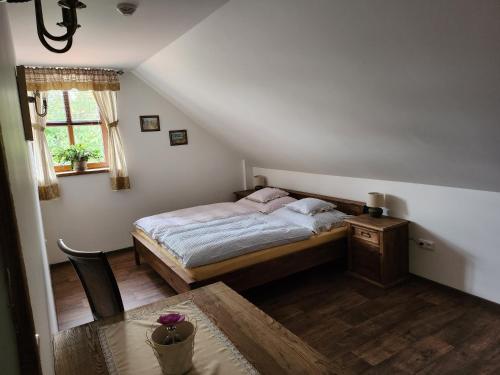 1 dormitorio con cama, mesa y ventana en Hospůdka Na Trucovně en Sázava